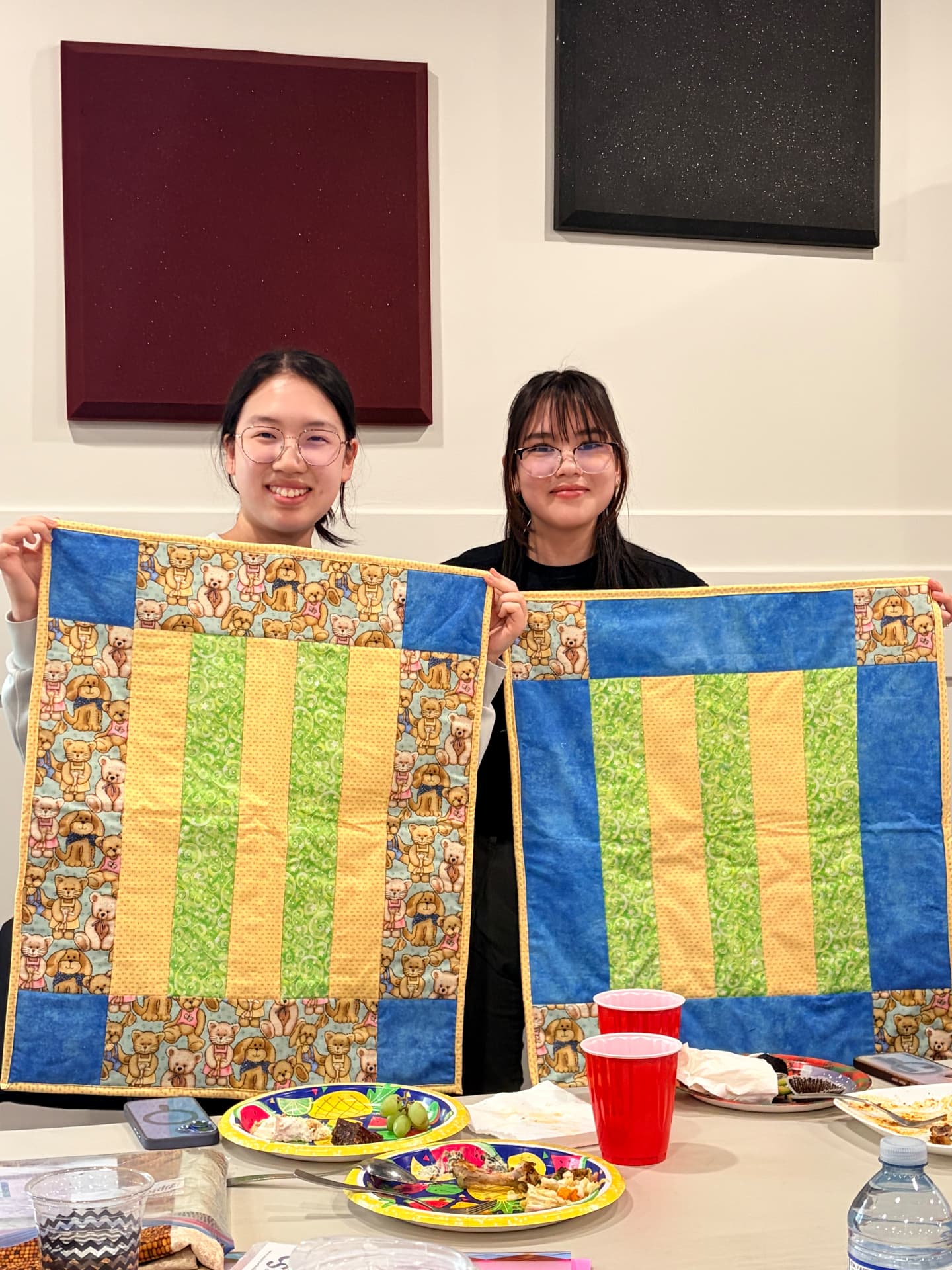 Two matching teddy bear baby quilts in blue, yellow, and green