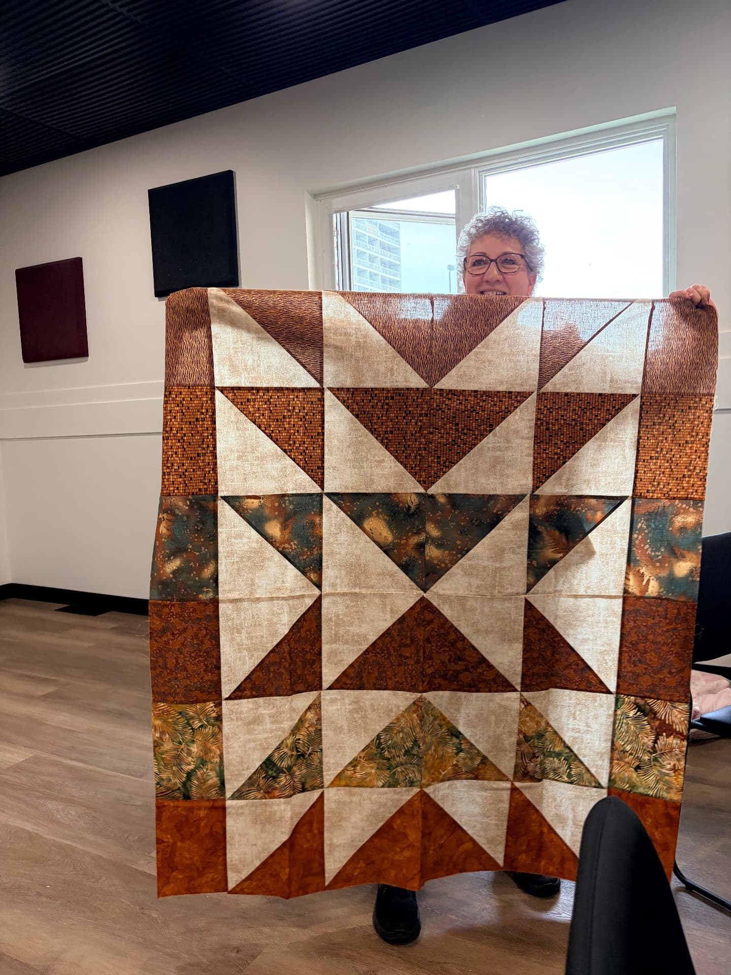 Half-square triangle star quilt in rust, teal, and cream batiks