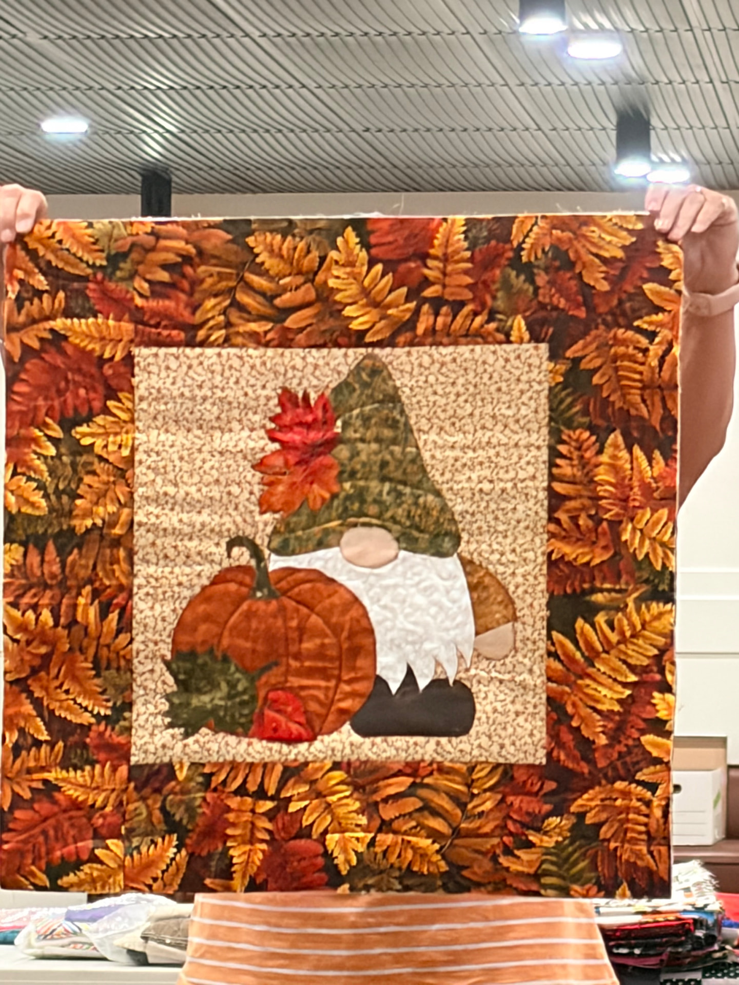 Finished September gnome block — an appliqué gnome in a green hat beside an orange pumpkin, framed by autumn leaves