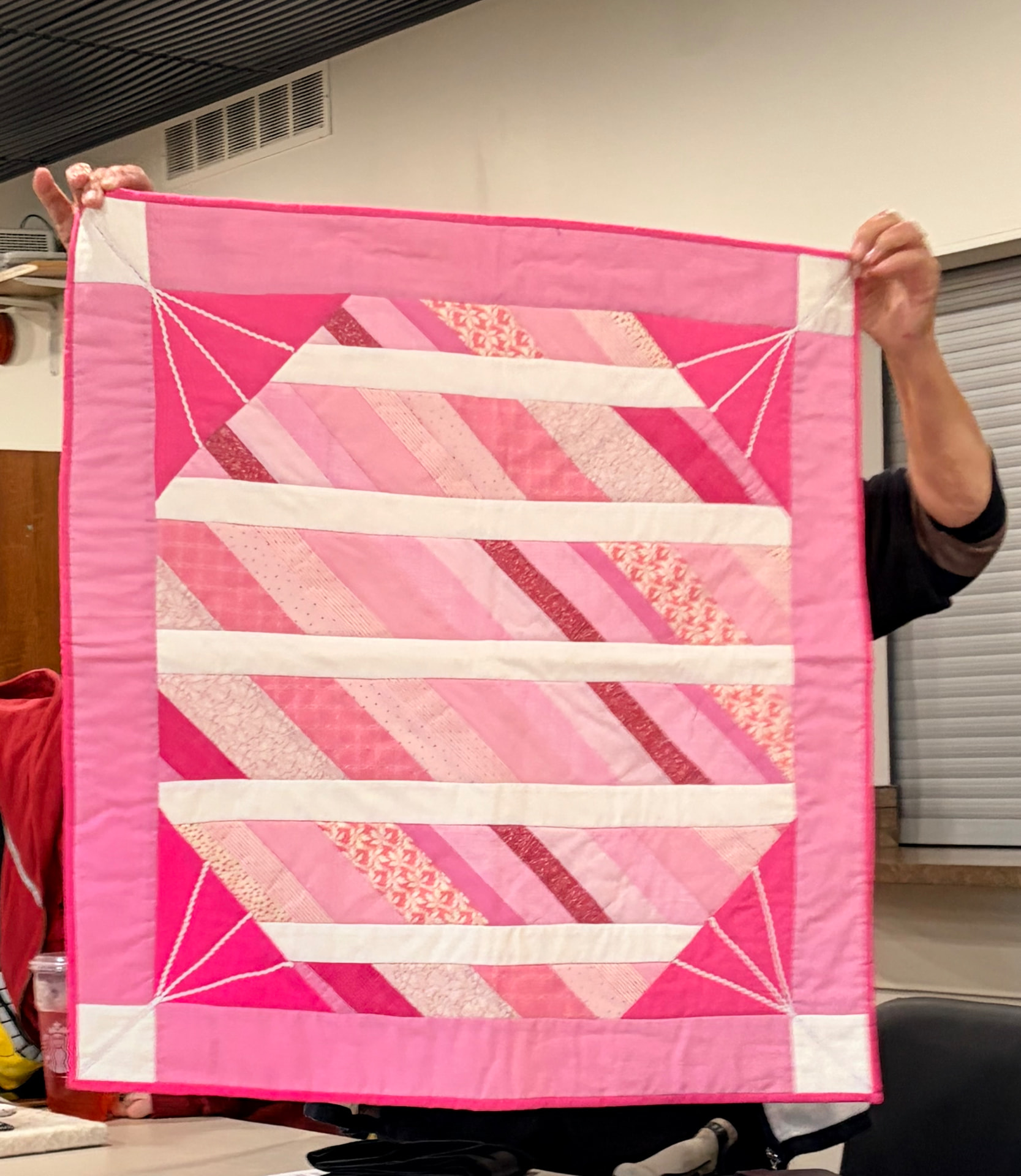 Pink string-pieced quilt with diamond centres and corner triangles
