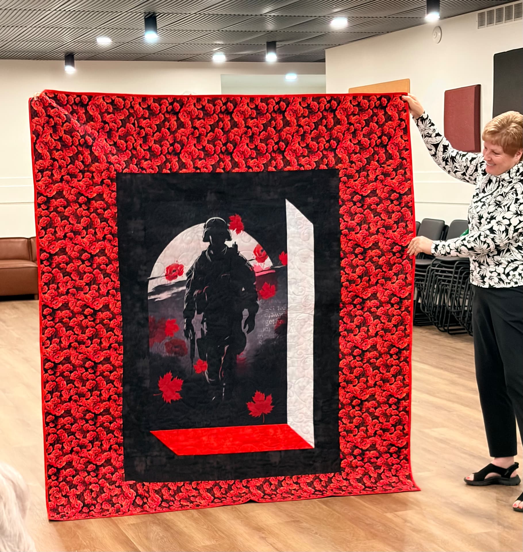 Remembrance quilt with a soldier panel framed by red poppy fabric