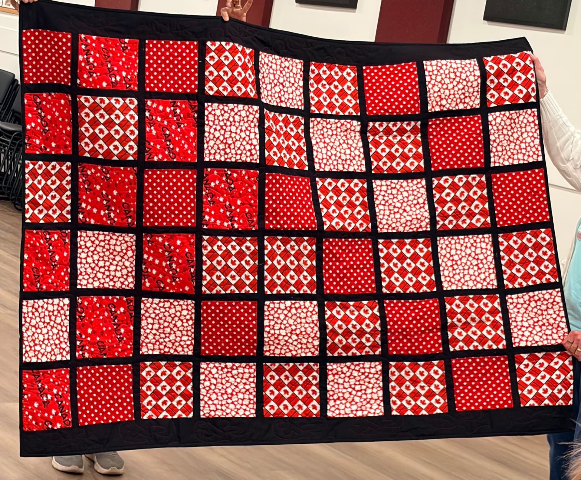 Red and white Canada squares quilt with black sashing