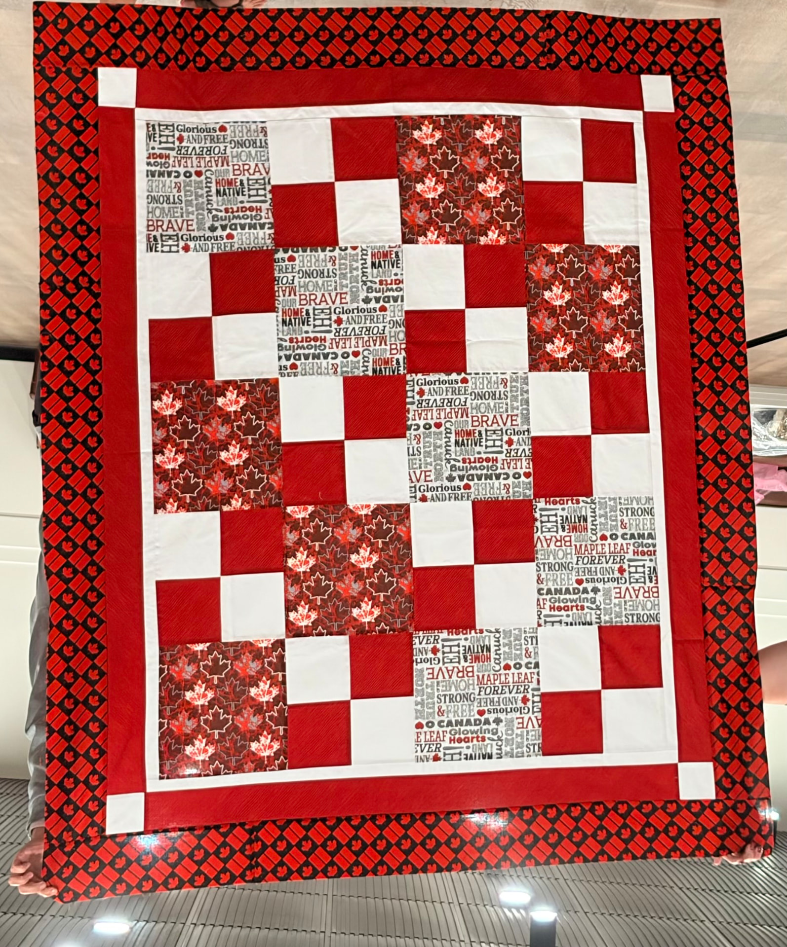 Canada quilt in red and white with a maple leaf checkered border