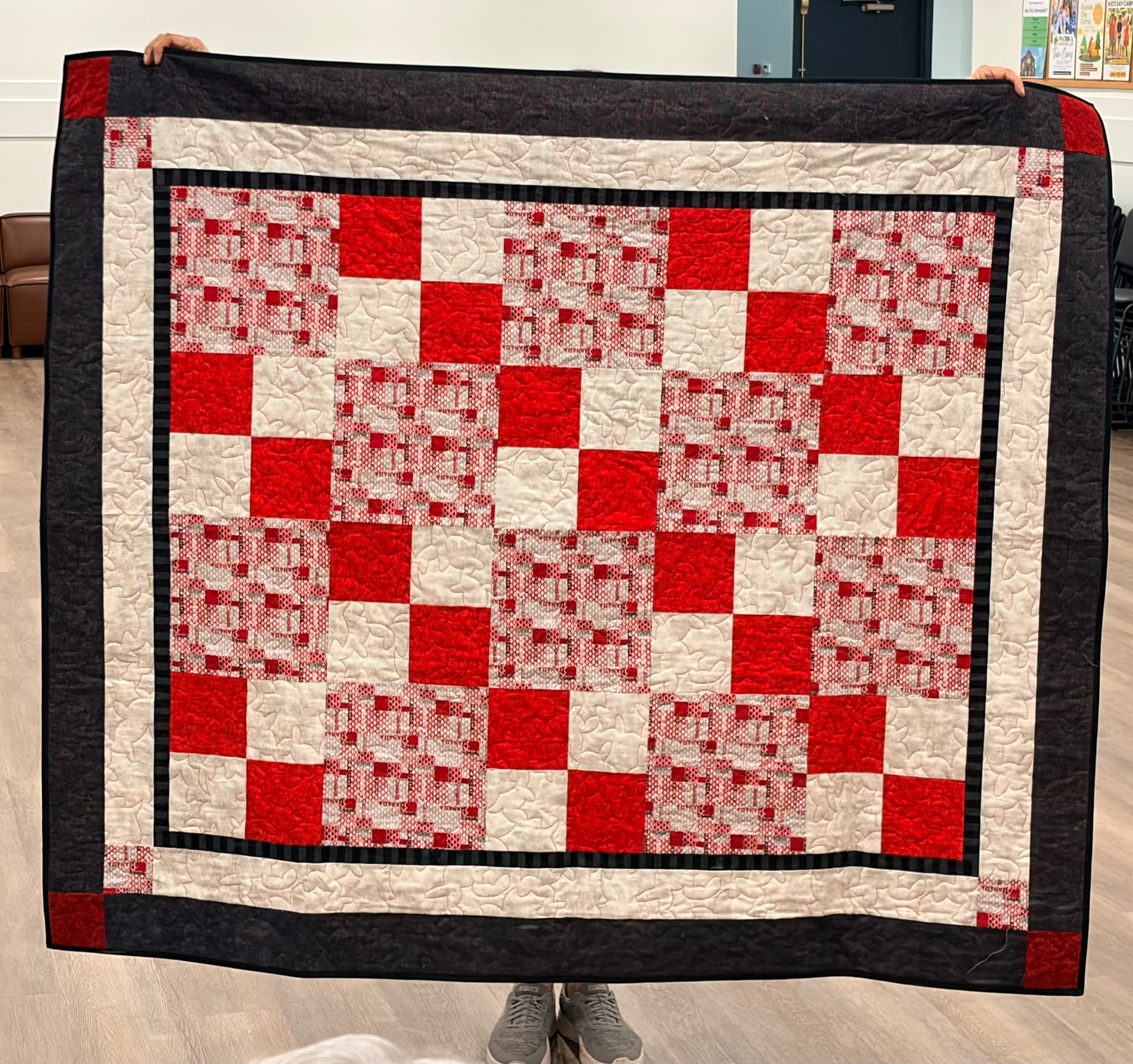 Red and cream checkerboard quilt with charcoal border