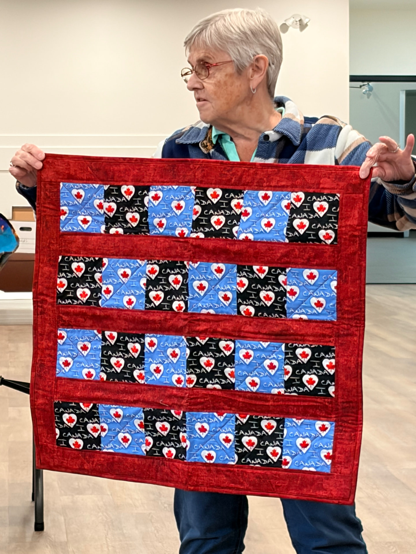 Canada hearts quilt with red border and blue, black, and white heart print blocks