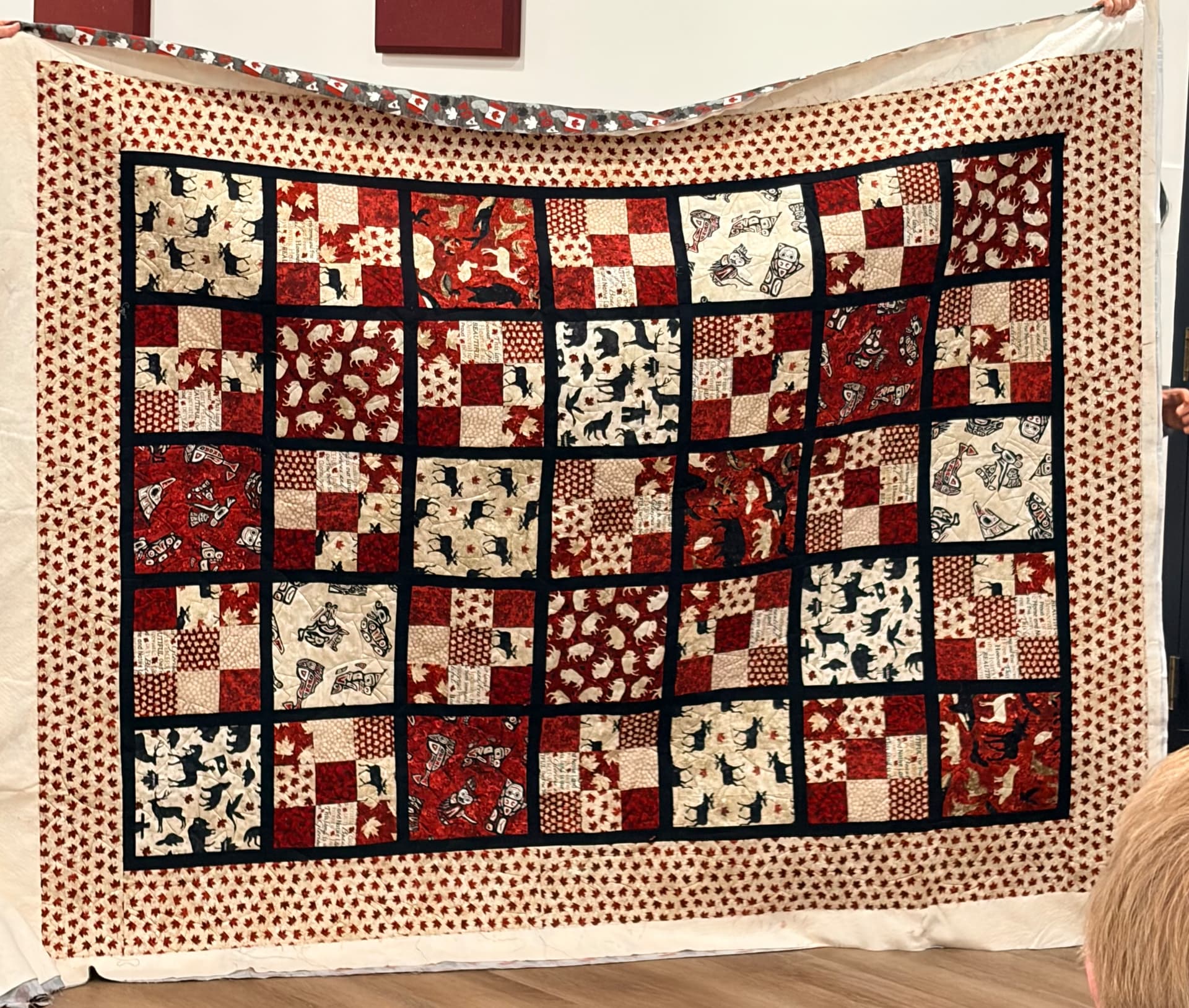 Red and cream Canadiana four-patch quilt with black sashing