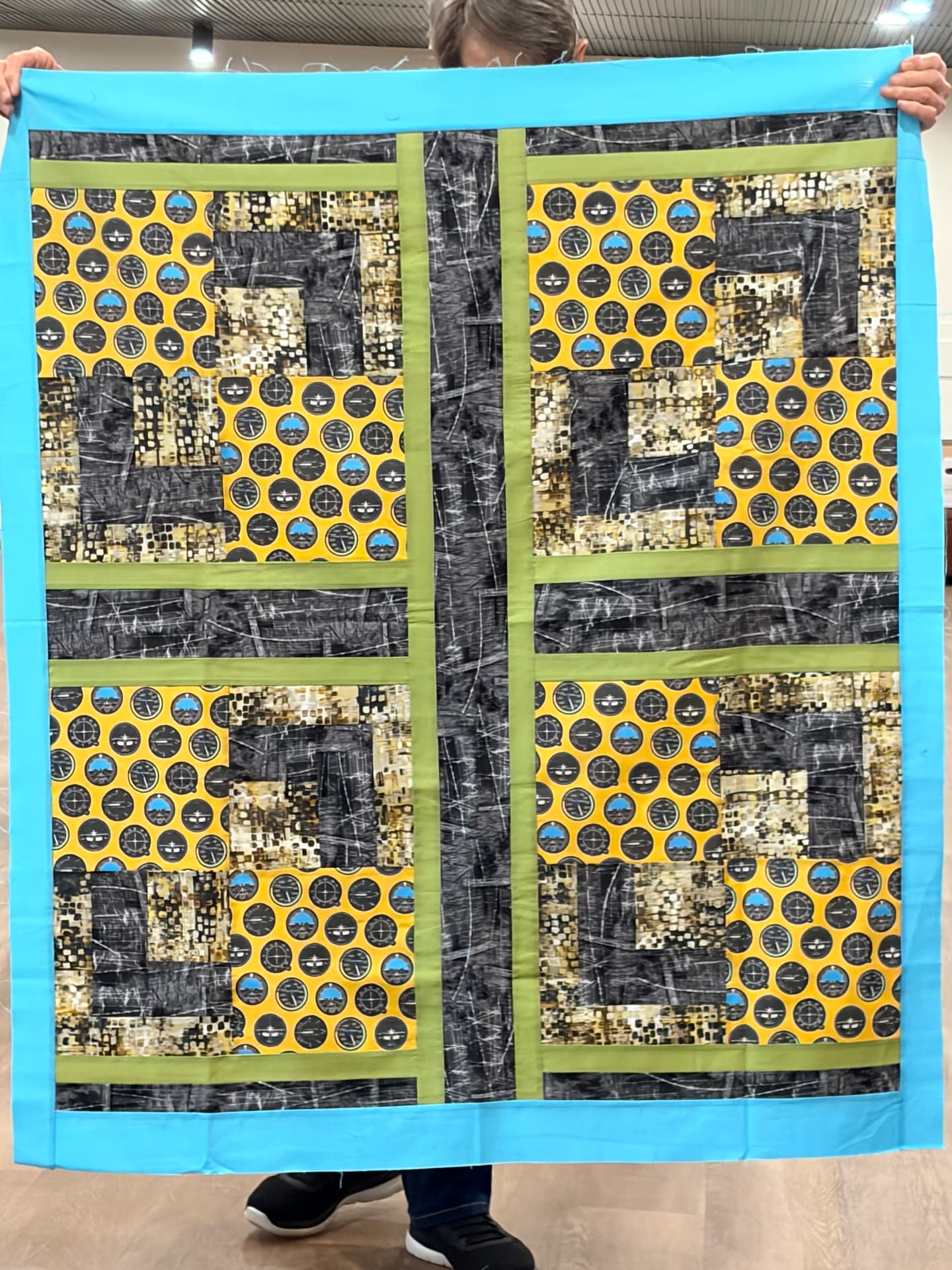 Aviation compass-print quilt in yellow, black, and blue with an aqua border