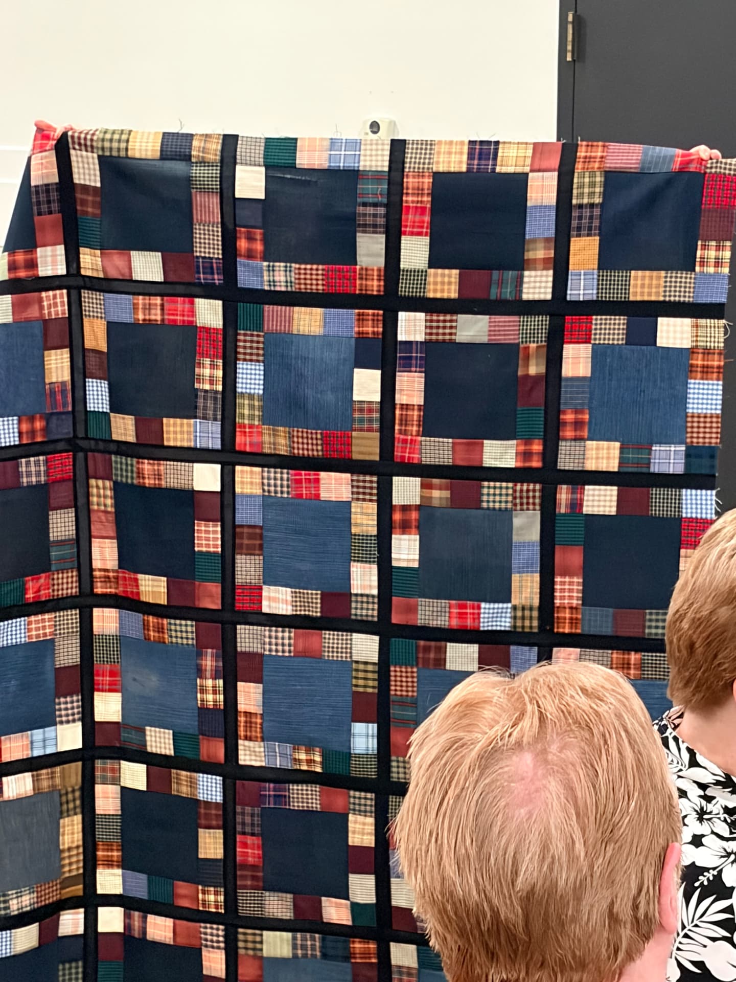 Navy and plaid patchwork quilt with black sashing
