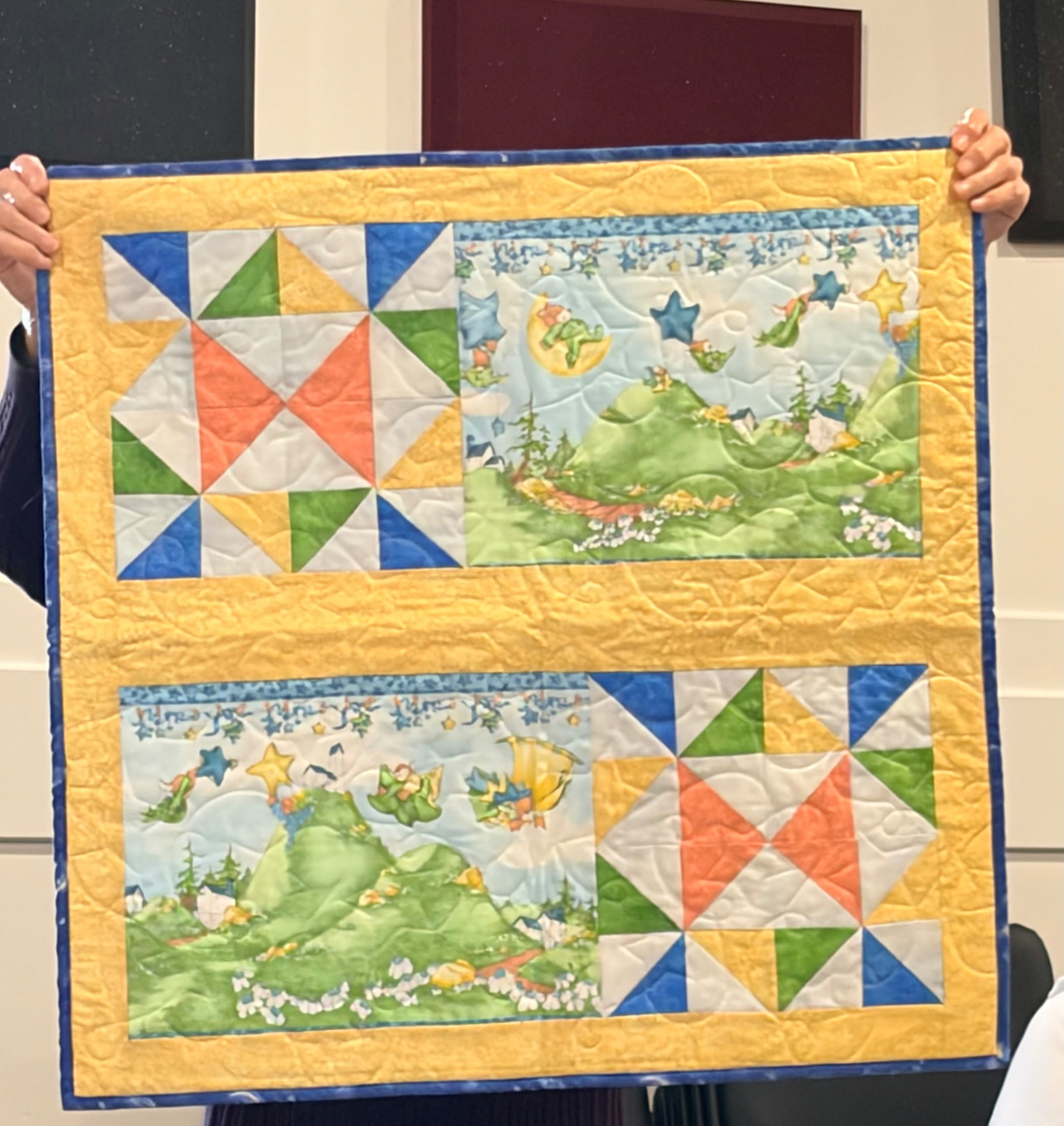 Moon-and-gnome print quilt in yellow and black with a teal border