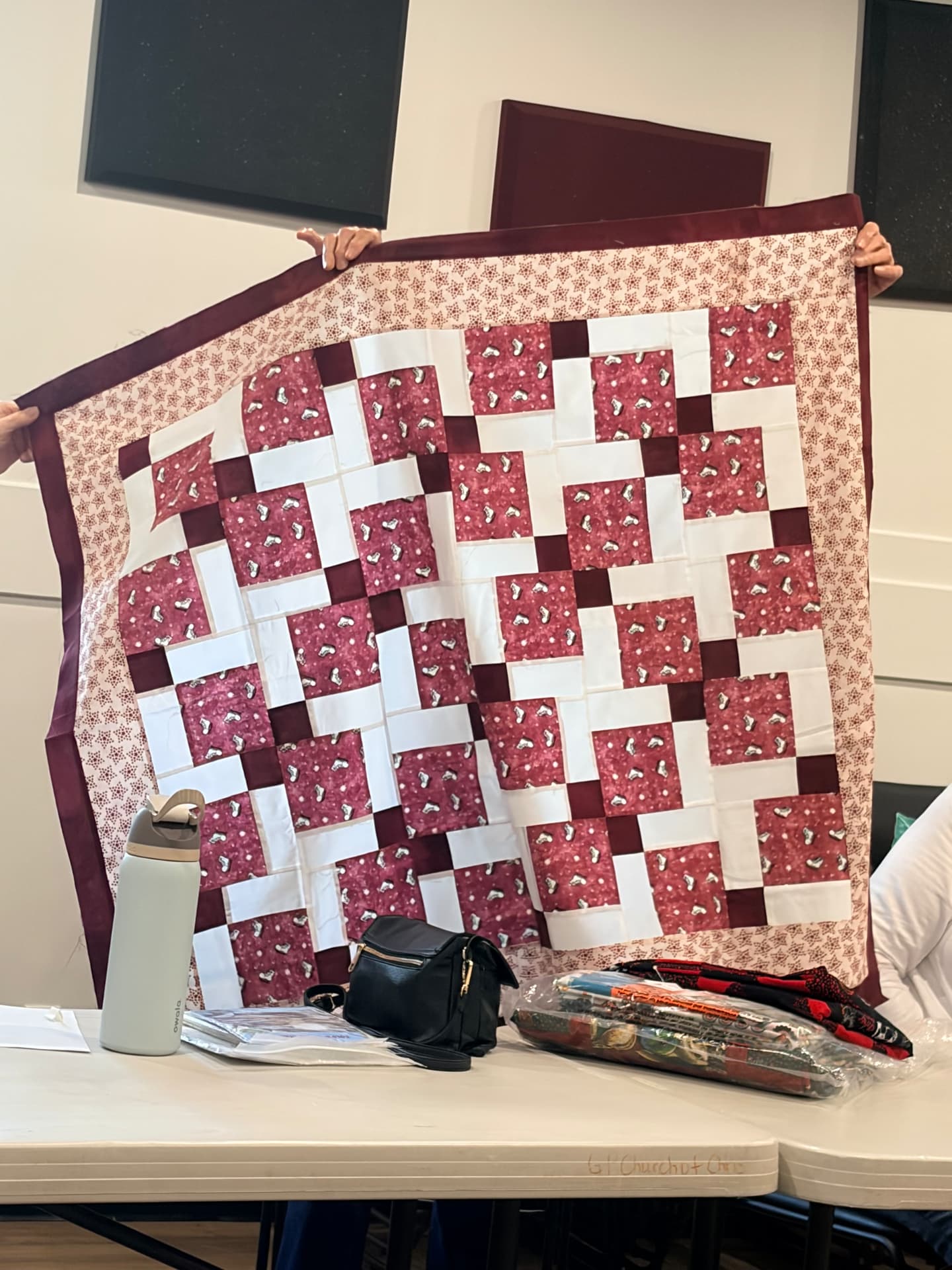 Disappearing nine-patch quilt in maroon, burgundy, and white with a star border