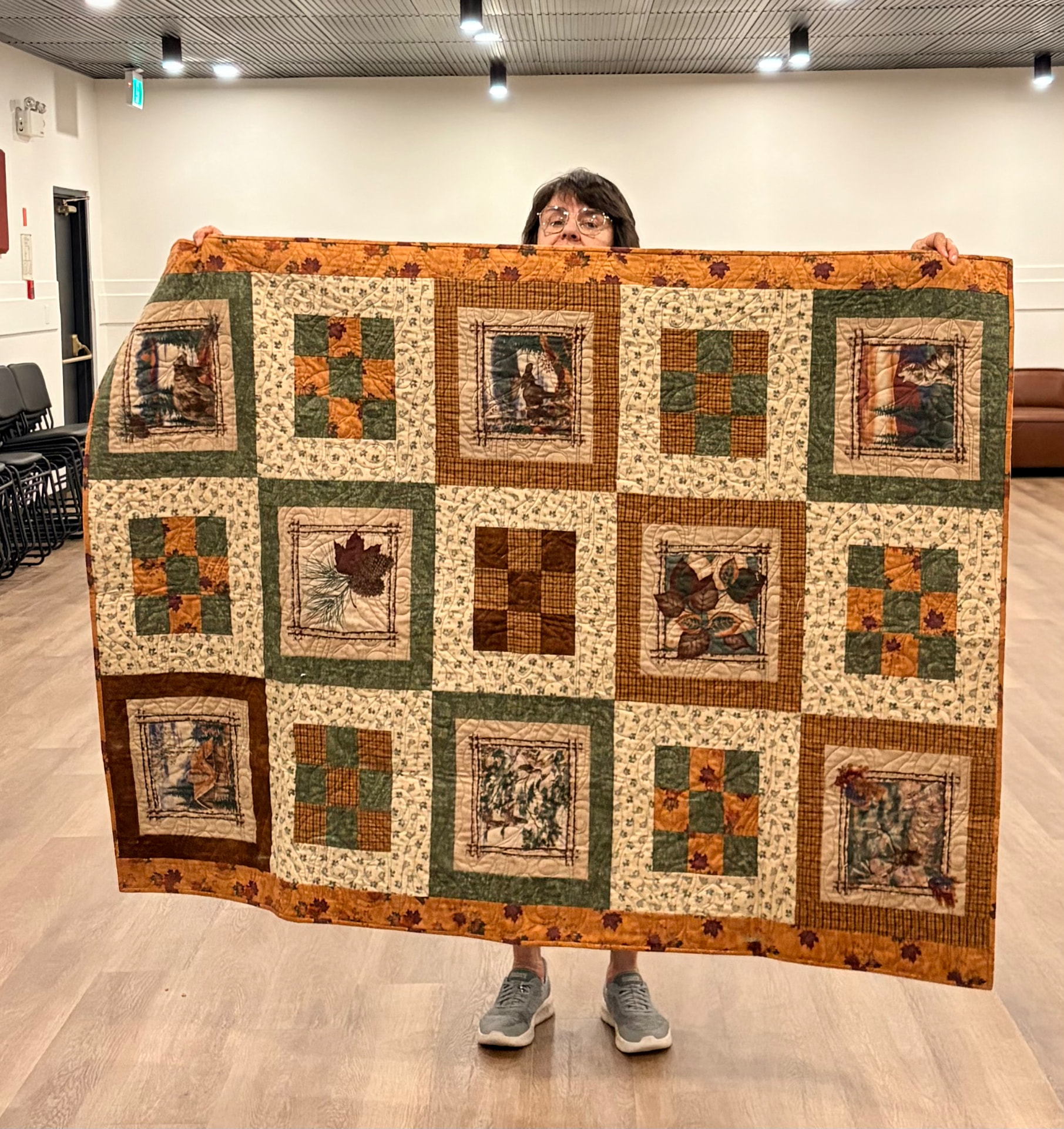 Autumn woodland panel quilt with nine-patch blocks in green, gold, and brown
